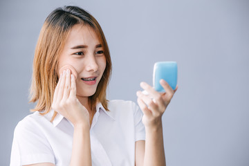 university uniform teen makeup her face with foundation powder