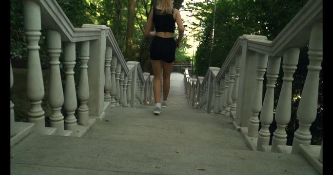 attractive girl teenager runs up the stairs in the park healthy lifestyle morning run jogging youth beauty health sport motivation closeup soft focus toned image