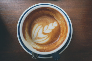 Top half of coffee with latte art  on wooden table