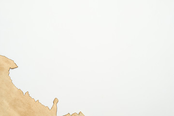 Fototapeta premium Cropped shot of old stained beige paper piece with burnt edge on white background. Vintage texture abstract design. Copy space.