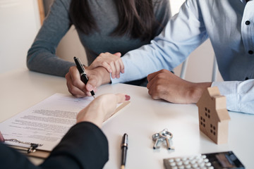 Salesmen are letting the male customers sign the sales contract, Asian women and couple are doing business in the office, Business concept and contract signing