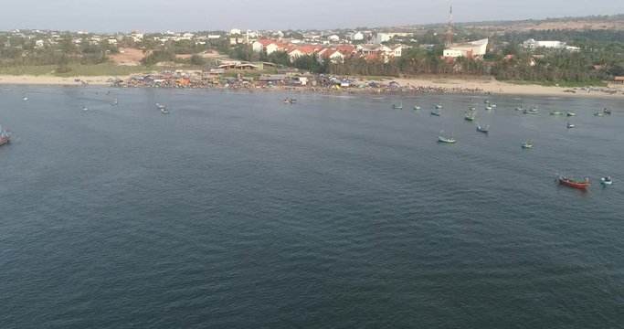 Top view, aerial view fishing harbor market from a drone. Royalty high-quality free stock video footage of market at Mui Ne fishing harbour or fishing village. Fishing harbor is a popular tourist 