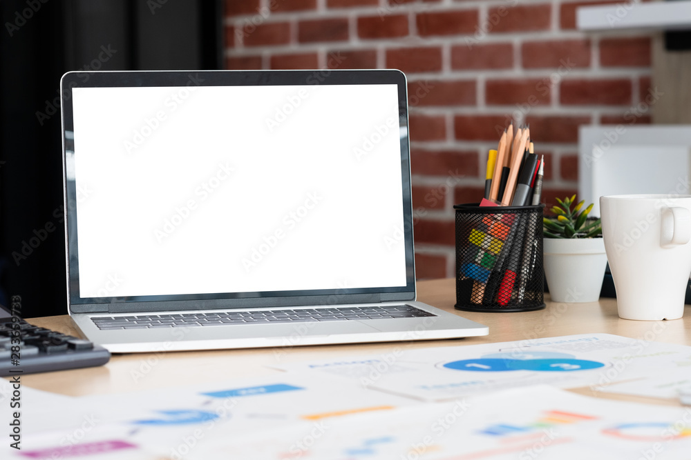 Aufkleber mockup laptop computer screen with business chart market,caculator,coffee cup,pencil box on desk at 