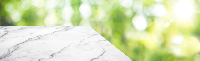 marble table top product display background with blur nature garden.left perspective wooden kitchen counter with green leaf and sunlight.Banner mockup presentation for your product on online media
