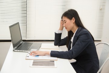 Asian Young beautiful business woman suffering stress working at office from feeling tired and desperate looking overworked and   overwhelmed and frustrated. .