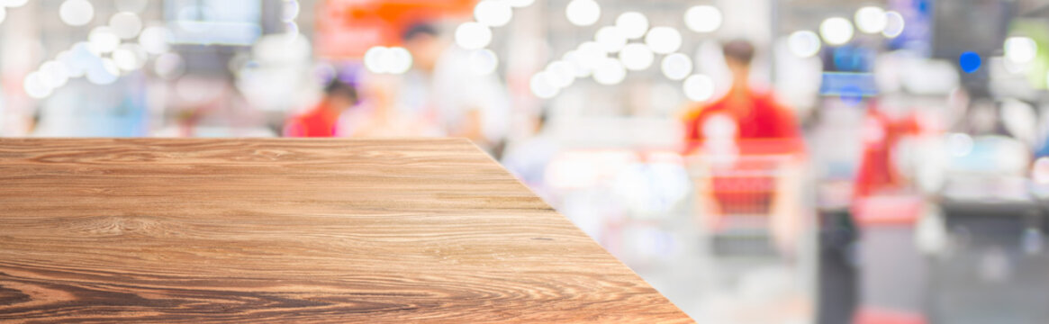 Wood Table Top Product Display Background With Blur People Shopping In Supermarket.left Perspective Wooden Cashier Counter With Customer Product Cart.Banner Mockup Presentation For Your Product Online