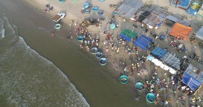 Top view, aerial view fishing harbour from drone. Royalty high-quality free stock footage of basket boat at Mui Ne fishing harbor or fishing village. Fishing harbor is a popular tourist destination