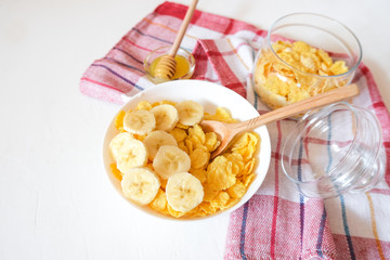 Traditional breakfast cereal of cornflakes and milk with a banana. Healthy lifestyle food.