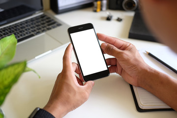 Cropped shot view of man hands holding smart phone with blank copy space screen for your text message or information content, female reading text message on cell telephone during in urban setting. 