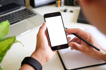 Cropped shot view of man hands holding smart phone with blank copy space screen for your text message or information content, female reading text message on cell telephone during in urban setting. 