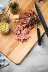 Gegrilltes Schweinefleisch Haxen Fleisch auf Holzbrett mit Cornichons, süßen und mittelscharfen...