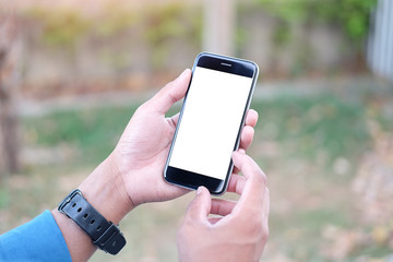 Cropped shot view of man hands holding smart phone with blank copy space screen for your text message or information content, female reading text message on cell telephone during in urban setting. 