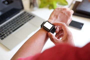 Cropped shot view of Businessman Looking At Smart Watch In Design Office .
