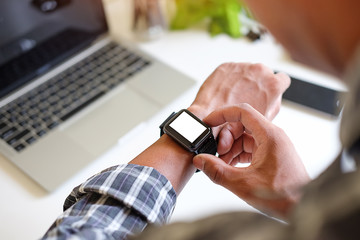 Cropped shot view of Businessman Looking At Smart Watch In Design Office .