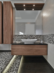 in the foreground the cabinets sink  with  conuter top washbasin and wood floor in the modern...