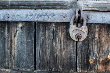 old padlock hanging on the old wooden door