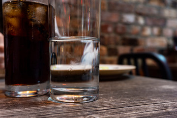 Glass of water and cola on a irish pub.