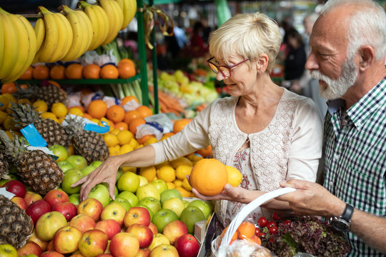 Only the best fruits and vegetables. Beautiful senior couple buying fresh food on market