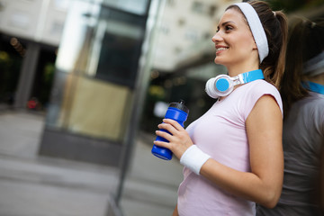 Beautiful sporty fit woman running and relaxing in city