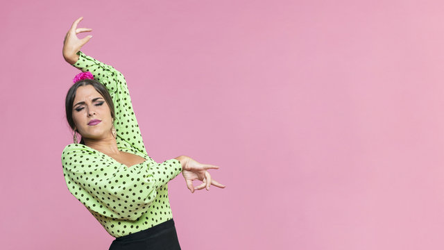 Medium shot flamenca performing floreo on pink background