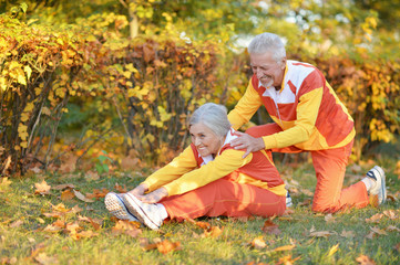 Naklejka na ściany i meble fit senior couple exercising in autumn park