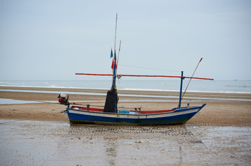 Naklejka na ściany i meble A blue fisherman boat on the beach