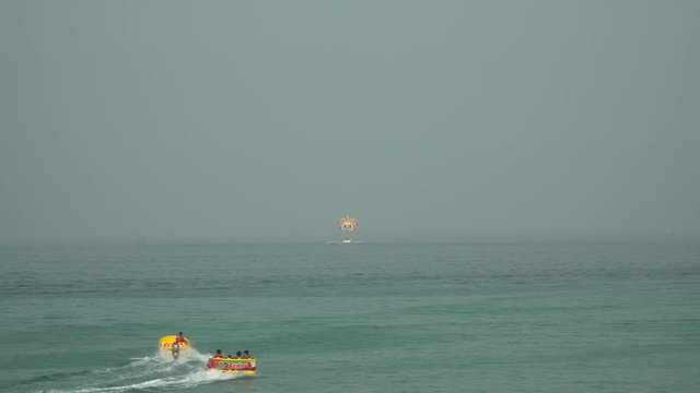 People enjoying summer water sea activities, parasailing