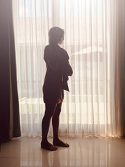 Fototapeta premium Woman with towel in front of a window and curtain.