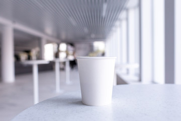 Close up of empty white cup on white interior 