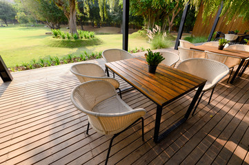 Wooden chair with table and green flora on patio