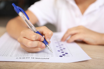 Naklejka premium Pupil passing school test in classroom, closeup