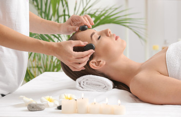 Obraz na płótnie Canvas Young woman having facial massage in beauty salon