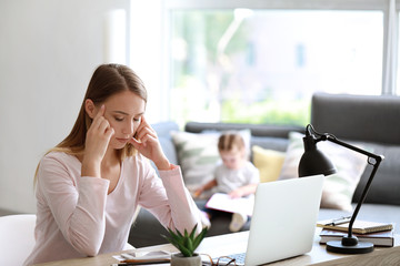 Tired young woman working at home