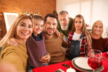 Happy family taking selfie during Christmas dinner at home