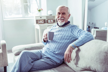 Obraz premium Modern retired man having some rest at home drinking cup of tea