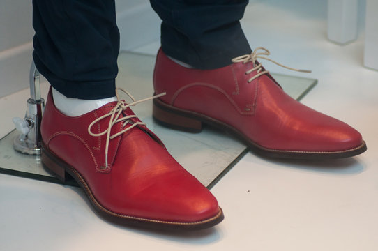 closeup of red leather shoes for men in fashion store showroom