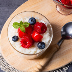 delicious milk rice with different berries and red fruit jelly