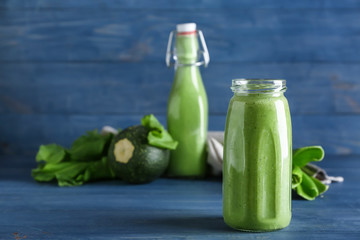 Bottle of tasty smoothie on wooden table