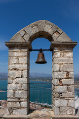 Obraz premium Bell on a stone arch overlooking city of Nafplio former capital of Greece, Peloponnese.