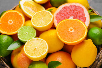 Different citrus fruits in basket, closeup