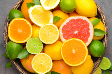 Different citrus fruits in basket, closeup