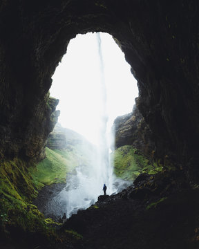 Wasserfall in einer H&ouml;hle in Island mit kleiner Person im Sommer