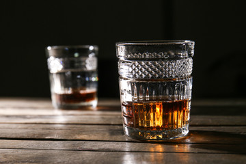 Glass of cold whiskey on wooden table