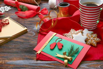 Handmade Christmas card with cookies and coffee on wooden table