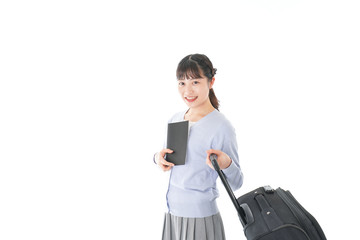 ガイドブックを持ち一人旅をする若い女性
