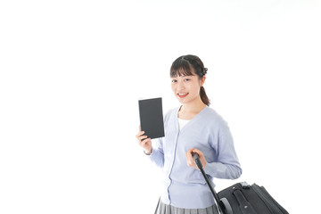 ガイドブックを持ち一人旅をする若い女性