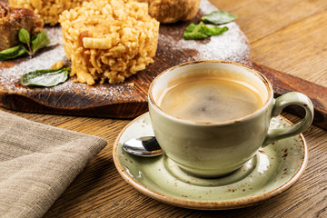 Cappuccino Cup with latte on wooden background. Beautiful foam, green ceramic Cup.