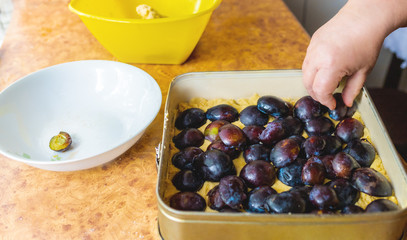Grandma baking plum cake.