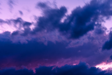 Blue hour sky clouds background. Beautiful landscape with clouds and purple sun on sky