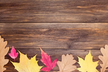 Naklejka na ściany i meble Frame from autumn leaves on wooden background. Card, invitation concept. Top view, flat lay, copy space, mock up, layout design